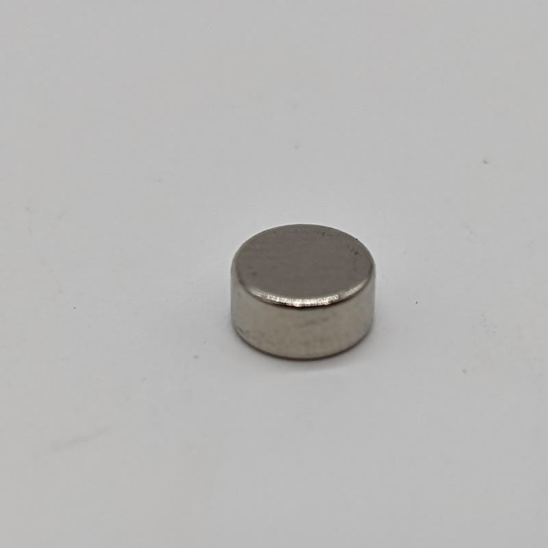 A small, cylindrical, metallic Magnet Round Neodymium N52 6x3mm with a smooth, reflective surface. The 3docity magnet is placed on a plain, light-colored background.